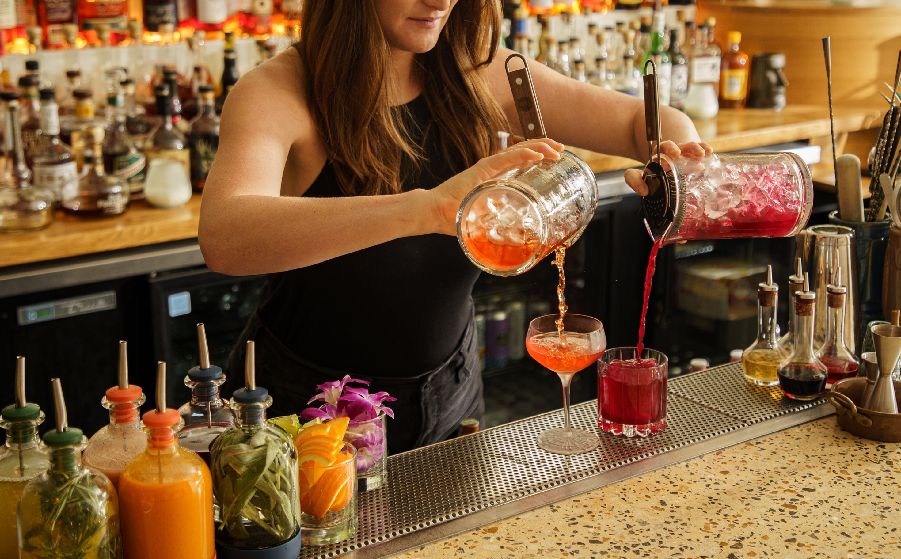 A bartender pouring with a Craft Tech® Mixing Glass and Standard Strainer