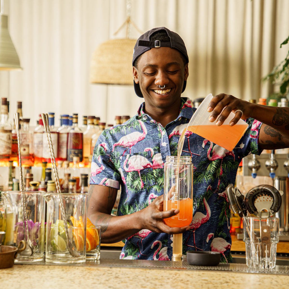 Bartender pouring juice into bar bottle