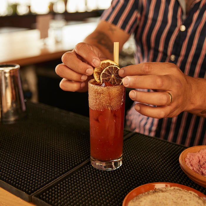 Bloody Mary garnished with lemon lime, plant-based straw and Bloody Mary rimming salt