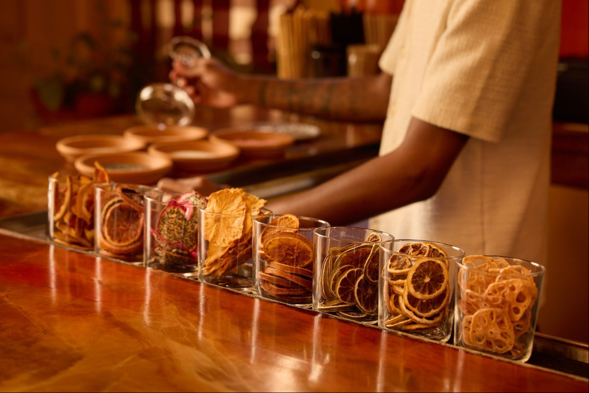 Row of dehydrated garnishes in glass containers on a bartop