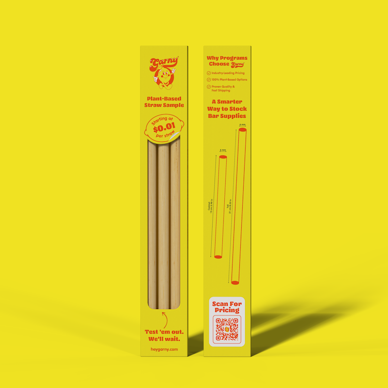 Two yellow cardboard boxes for Garny plant-based straw samples, standing upright on a bright yellow background. The left box shows several Bamboo Fiber straws and the back of the box displays printed product information and a QR code.