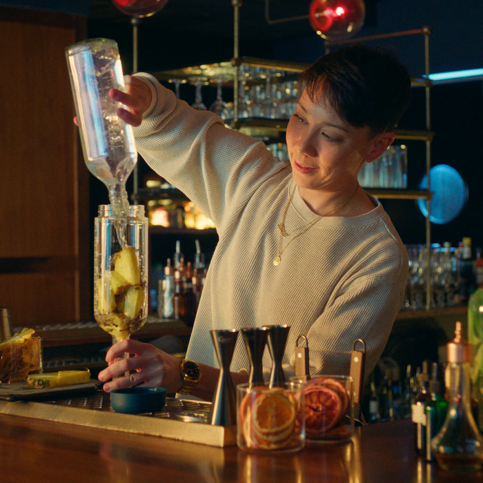 Bartender batching cocktail behind the bar