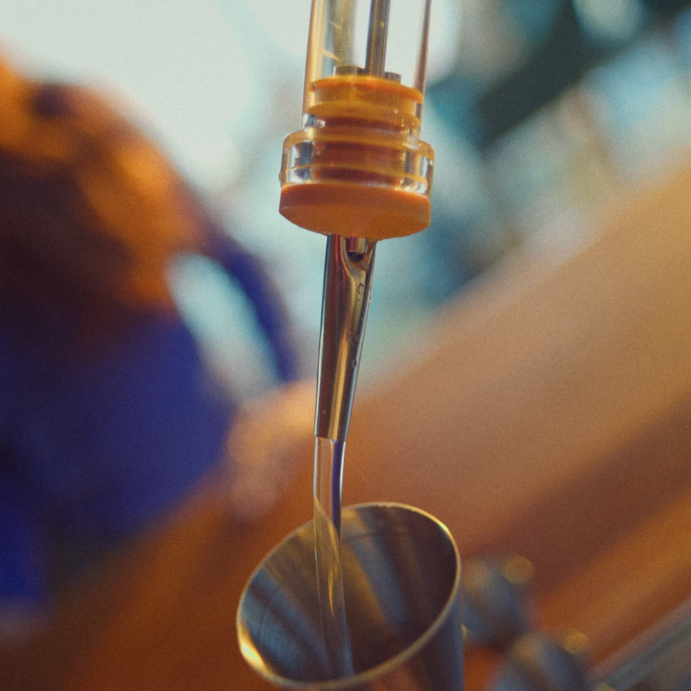Speed pourer pouring liquid into a jigger at a bar
