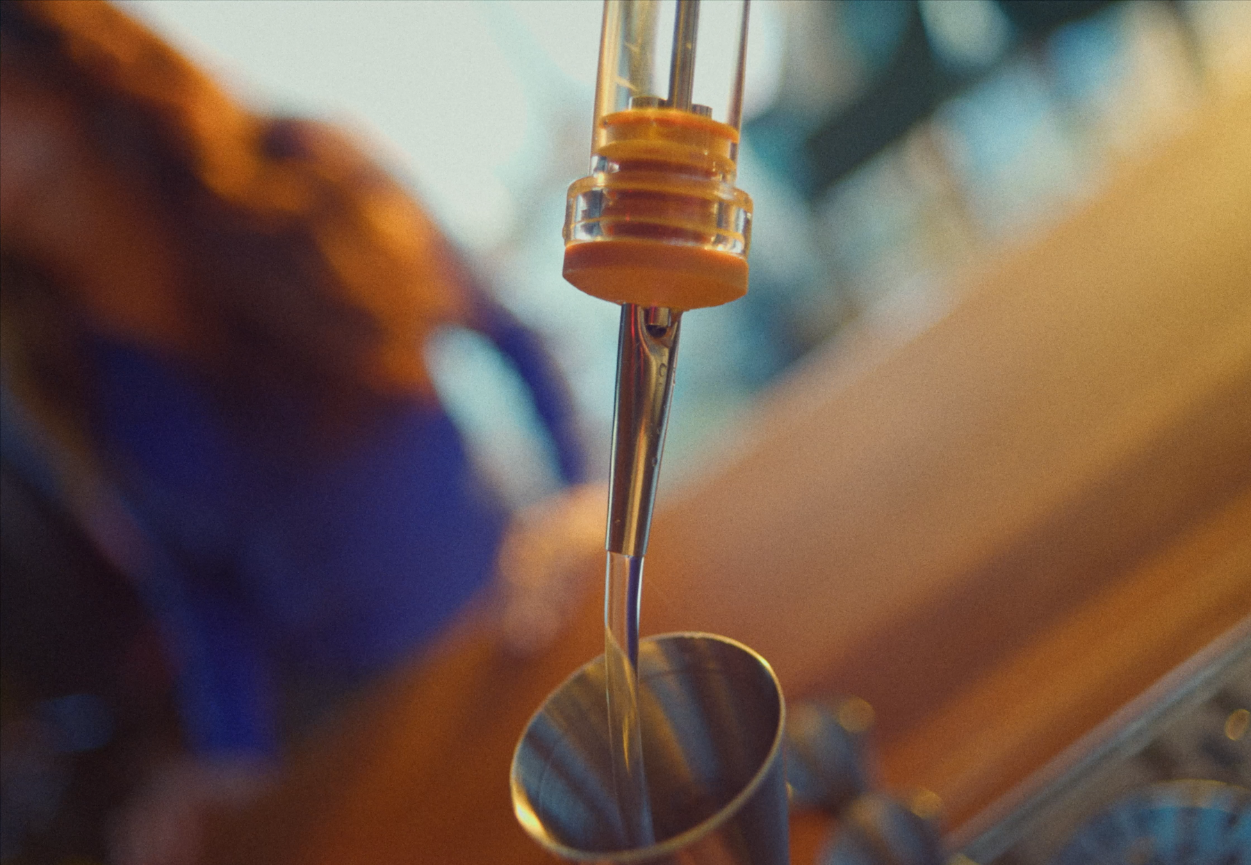 Speed pourer pouring liquid into a jigger at a bar