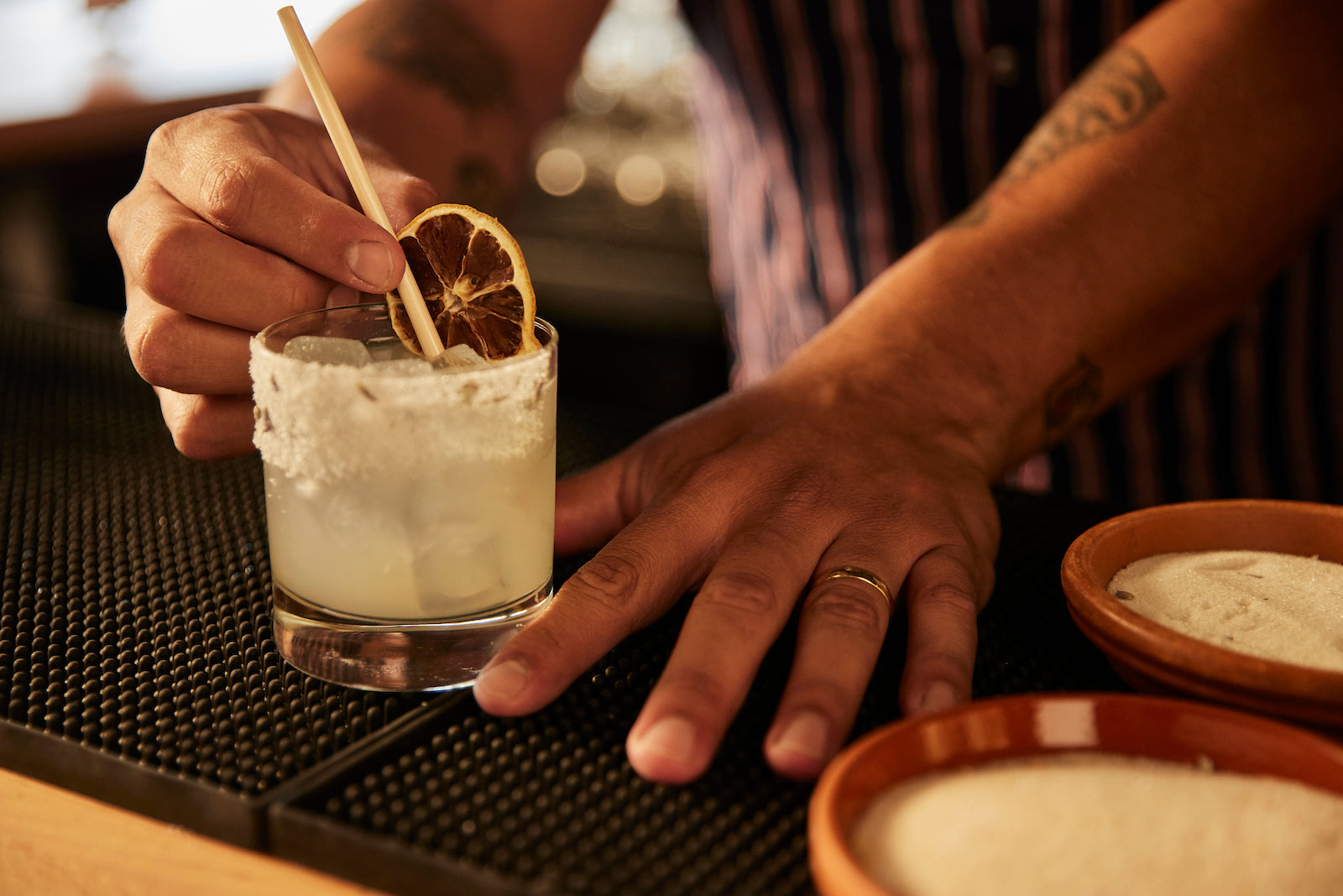 Bartender garnishing craft cocktail with bar supplies