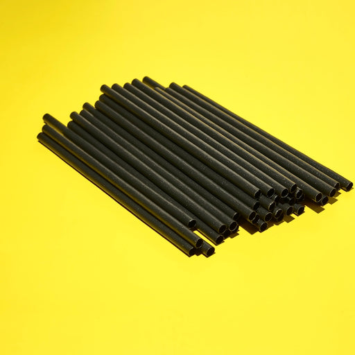 Pile of black plant-based agave straws for cocktails