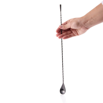 Cocktail bar spoon held by a hand on a white background