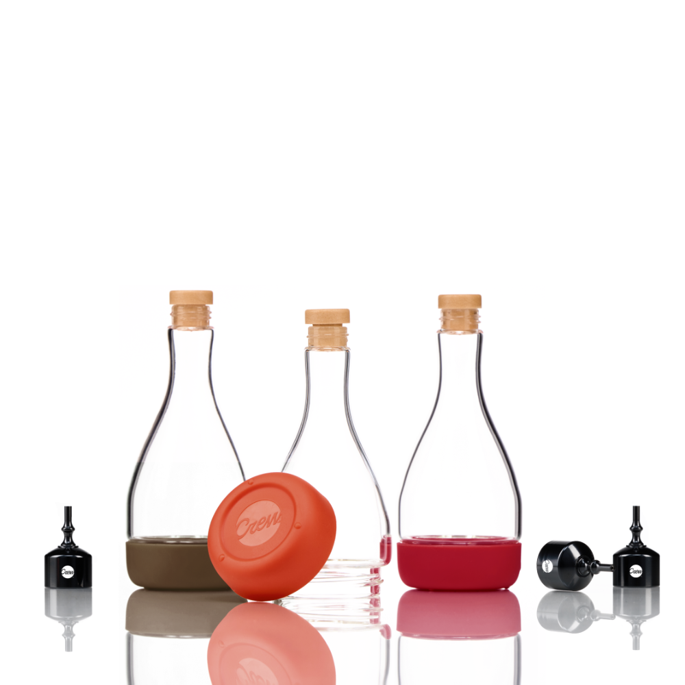 Three pack of threaded bitters bottles, brown, then orange, then red,. all with removable bases. by Crew barware on a white background. 