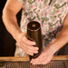 Bartender using Boston-style craft cocktail shaker tins with sleek matte black finish at an outdoor cocktail bar