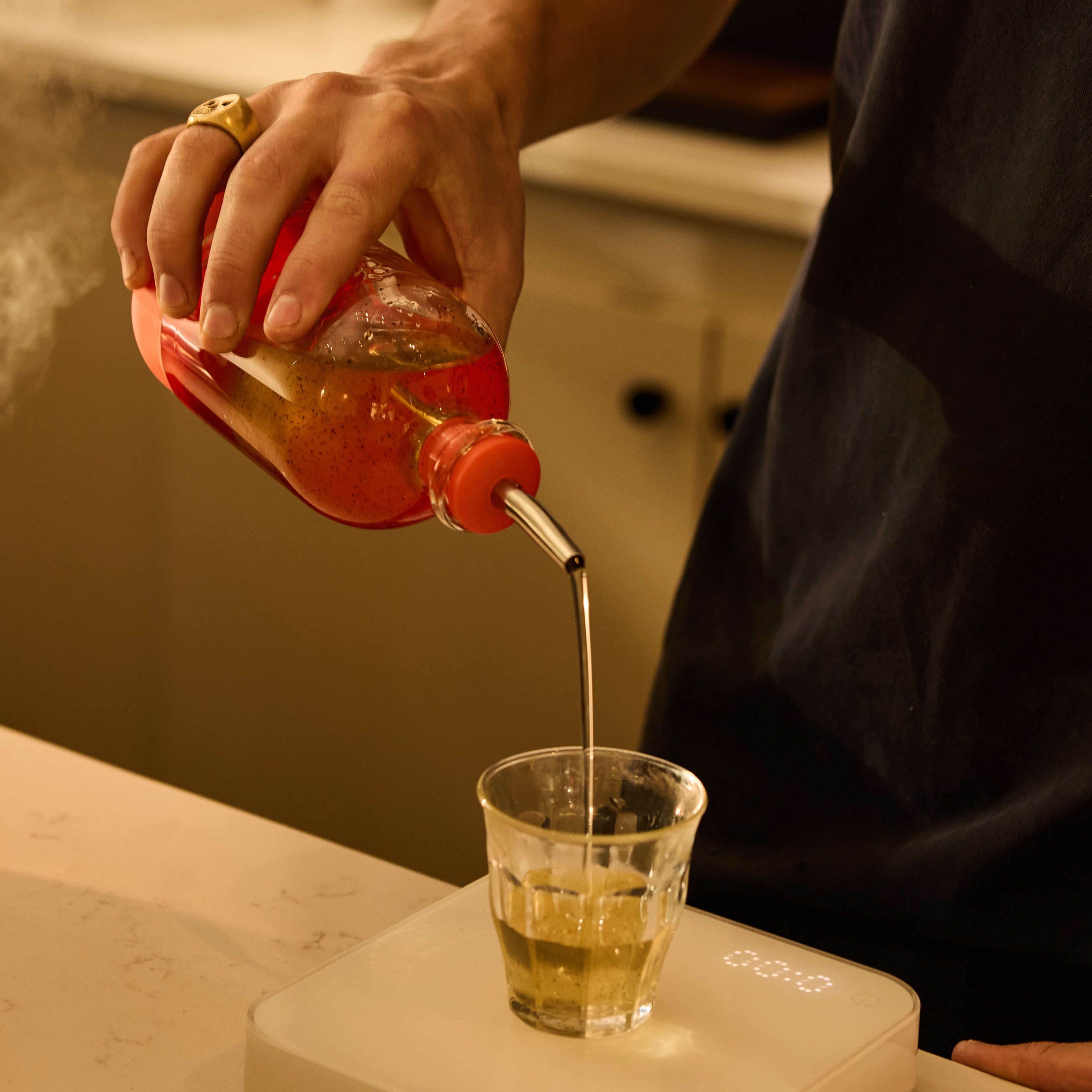 Speed pourer pouring coffee syrup into a cappuccino at a coffee shop