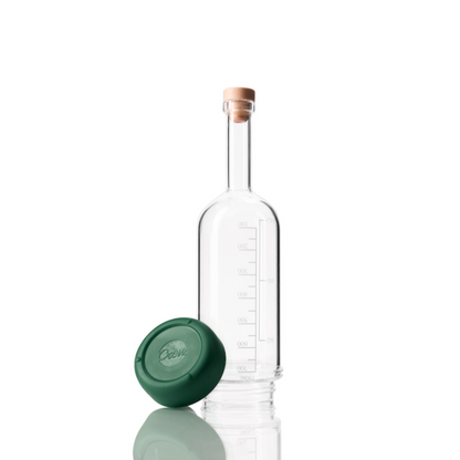 Clear glass bottle with a green removable base on a white background