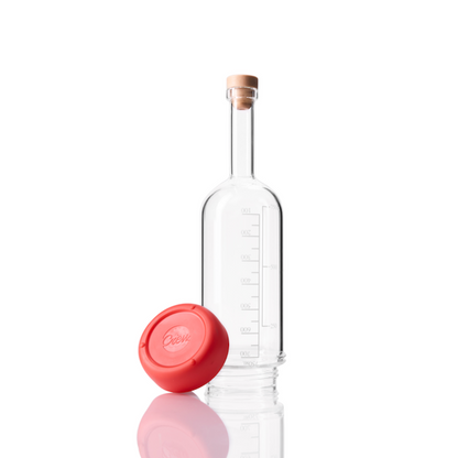 Glass Crew Bottle with measurement lines and a removable base Ruby color on white background
