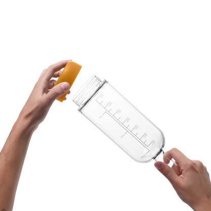 Glass pre-batch bottle with Marigold removable base being held by a person on a white background