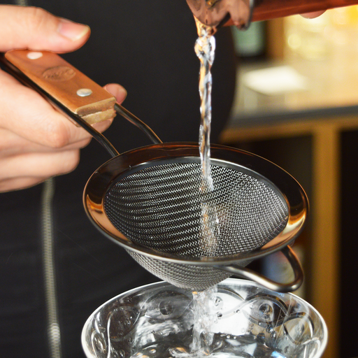 Bartender Pouring Liquid through Fine Mesh Strainers for Cocktails