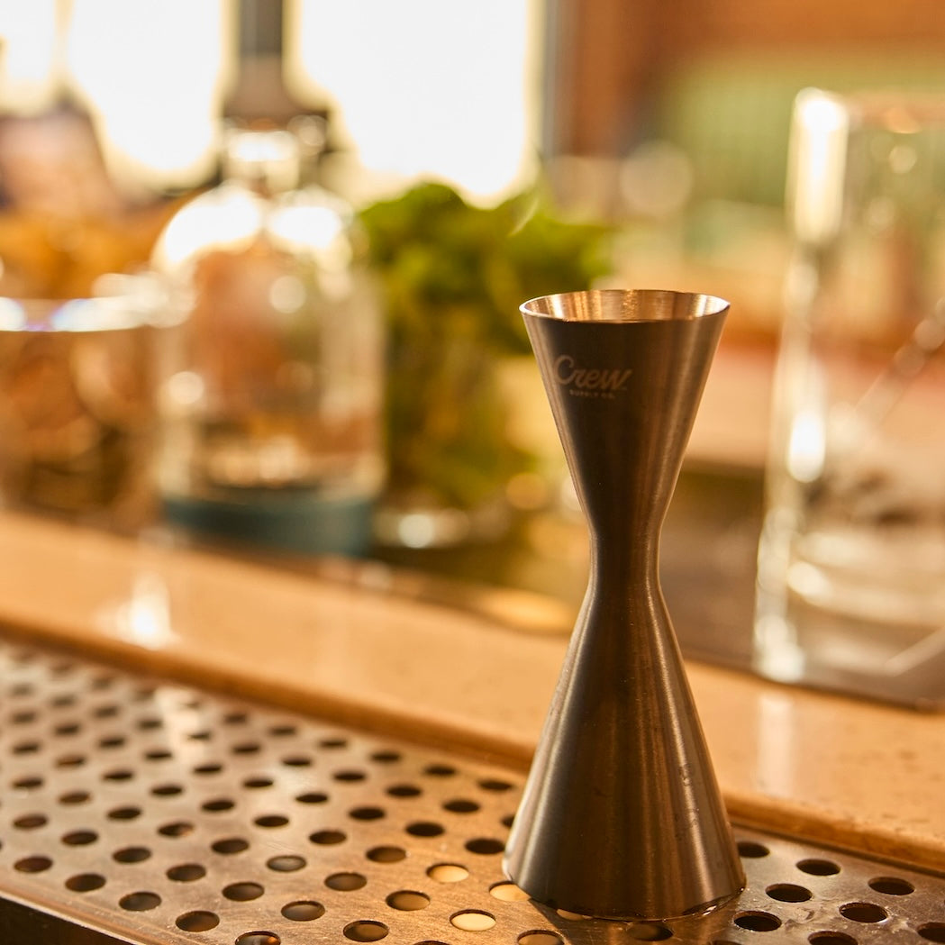 Stainless steel cocktail jigger on a bar counter