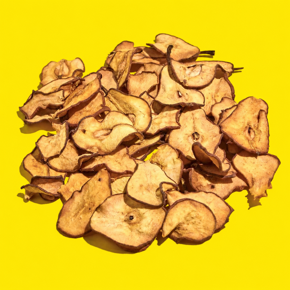 Pile of dehydrated pear slices for cocktail garnishes on a yellow background