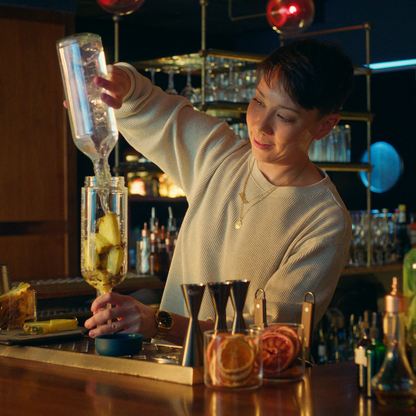 Bartender batching cocktail behind the bar