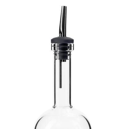 Glass batch bottle with black pour spout on a white background