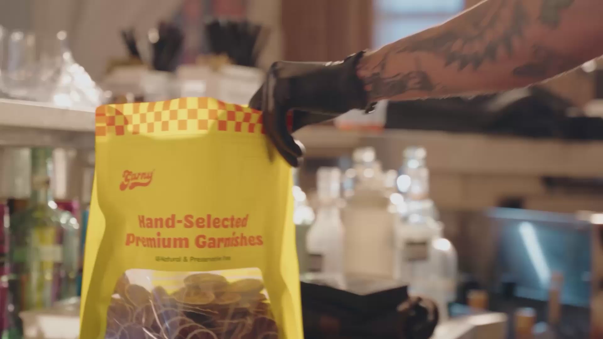 Load video: Hero video where bartender stocks cocktail garnishes from a Garny product pouch, and places plant-based-based straws into cocktails behind the bar. 