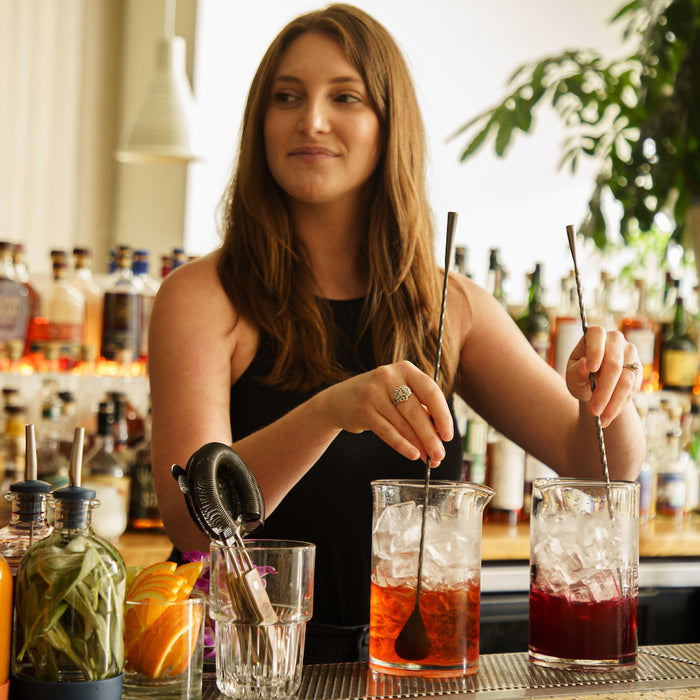Bartender stirring two cocktails at once