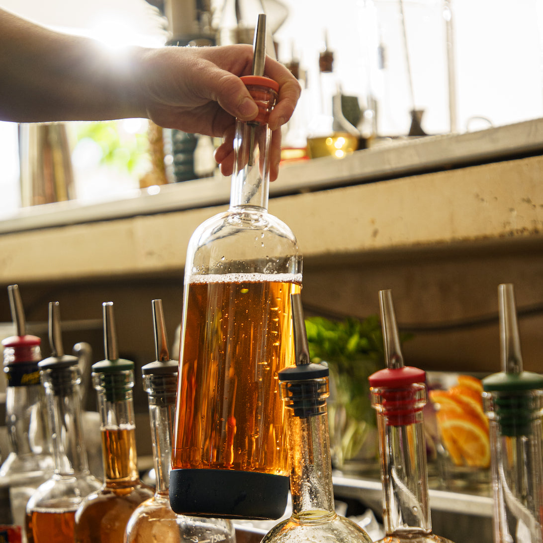 Person grabbing bar supplies including a crew bottle with a pour spout